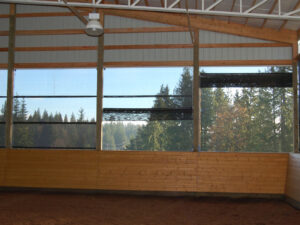 A GaleShield SLIDE-UP Screen Kit installed on an arena Side wall for protection from wind, rain, snow, sleet and hot, drying sun.